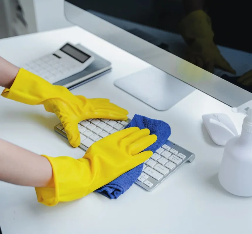 Nettoyage d'un poste de travail : clavier et bureau désinfectés